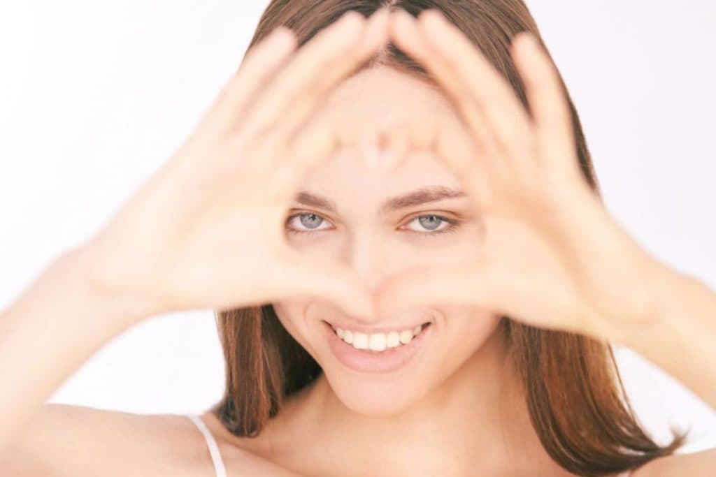 woman-with-heart-sign-focused-on-eyes