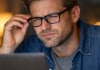 5 Signs It’s Time to Update Your Glasses Prescription (Don’t Wait!) Person wearing glasses squinting at a laptop screen.