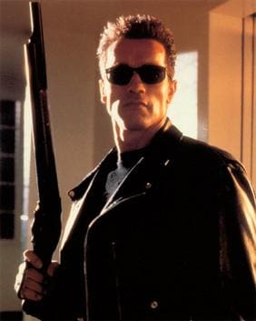 The Terminator wearing black sunglasses and a black leather jacket while holding a shotgun in The Terminator.
